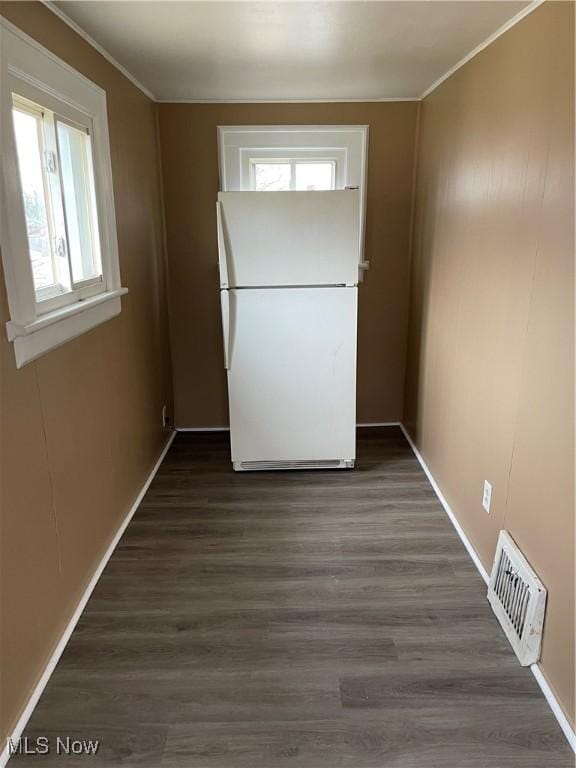 unfurnished dining area featuring visible vents, wood finished floors, and ornamental molding