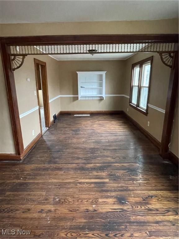 unfurnished room featuring dark wood finished floors and baseboards