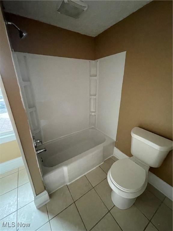 bathroom featuring tile patterned floors, baseboards, shower / tub combination, and toilet