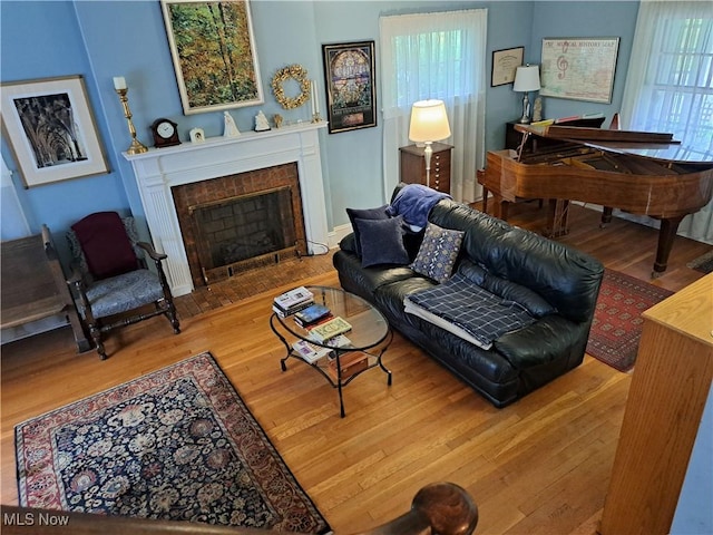 living area with a fireplace with flush hearth and wood finished floors