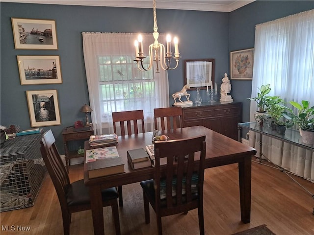 dining area with a notable chandelier, wood finished floors, and ornamental molding