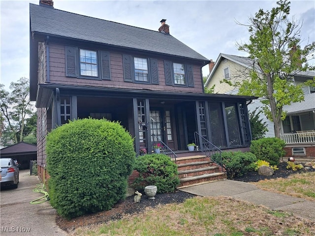 view of front of house featuring covered porch and a chimney