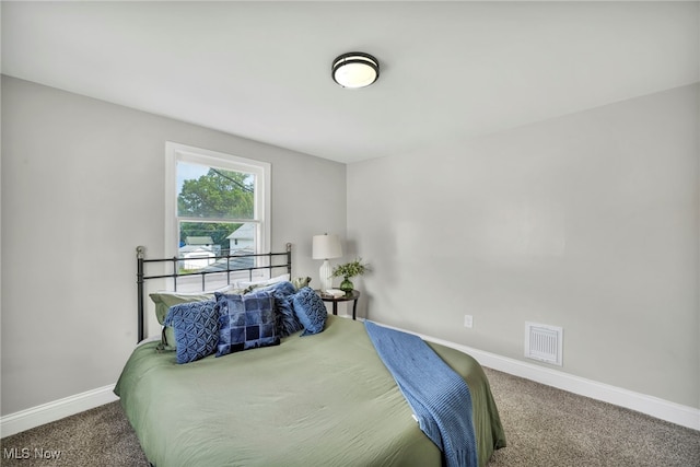 carpeted bedroom featuring visible vents and baseboards