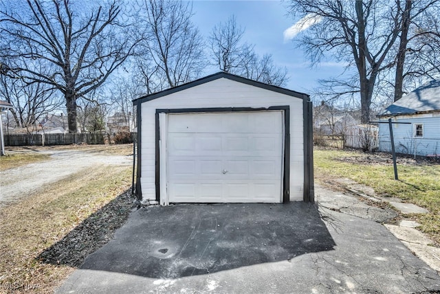 detached garage with aphalt driveway and fence