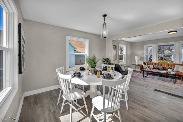 dining area with visible vents, baseboards, and wood finished floors