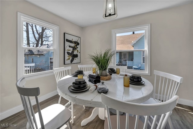 dining space featuring baseboards, plenty of natural light, and wood finished floors