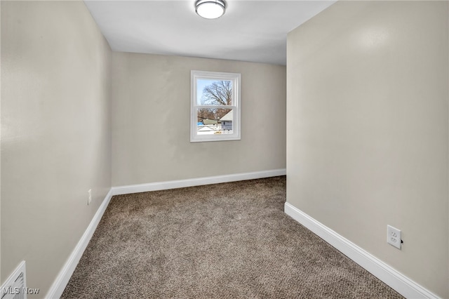 carpeted empty room featuring baseboards