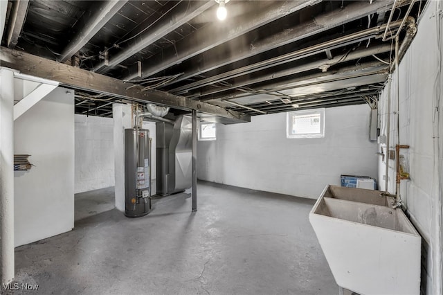 basement with gas water heater, heating unit, and a sink