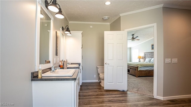 bathroom featuring toilet, ornamental molding, ensuite bathroom, a sink, and double vanity