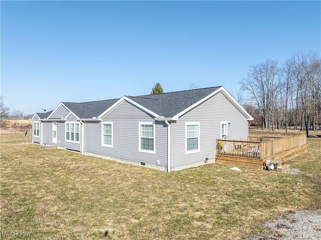 view of side of property with crawl space, a lawn, a wooden deck, and roof with shingles