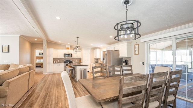 dining space featuring an inviting chandelier, light wood-style floors, and ornamental molding