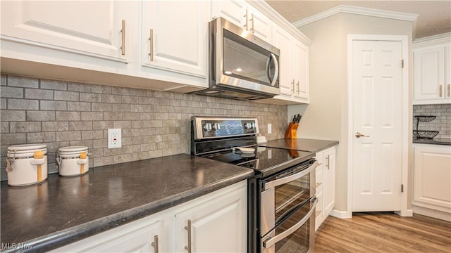5719 N Richmond Rd, Pierpont, OH 44082 - kitchen featuring stainless steel appliances, backsplash, white cabinets, dark countertops, and crown molding