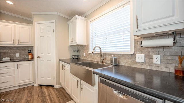 kitchen featuring a sink, stainless steel dishwasher, dark countertops, and white cabinets