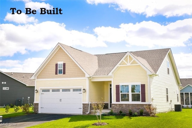 craftsman-style home featuring driveway, stone siding, a front yard, a garage, and central AC unit