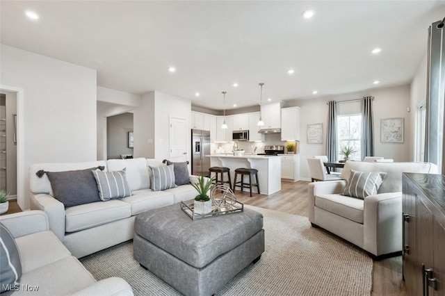 living room with recessed lighting and light wood-style flooring