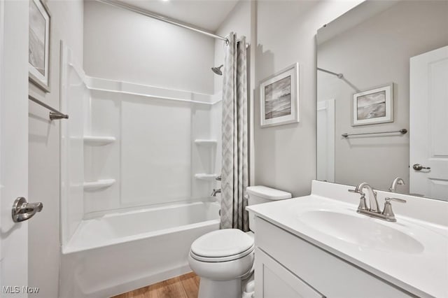 bathroom with wood finished floors, toilet, shower / tub combo with curtain, and vanity