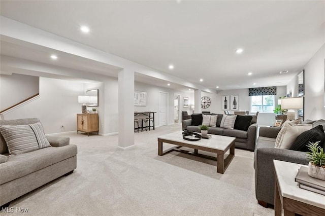 living room with recessed lighting, light colored carpet, and baseboards