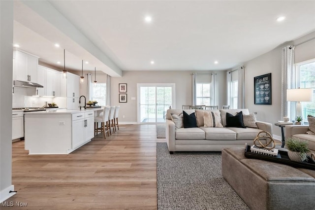 living area featuring a wealth of natural light, recessed lighting, and light wood finished floors