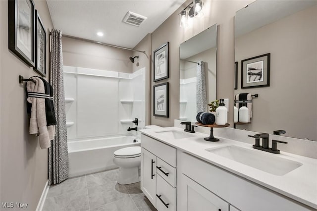 bathroom featuring double vanity, visible vents, toilet, and a sink