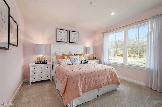 bedroom featuring baseboards and light colored carpet