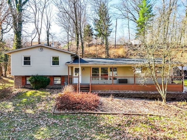 split level home featuring a porch and brick siding