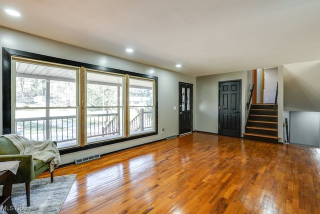 living room with recessed lighting, visible vents, stairs, and hardwood / wood-style flooring