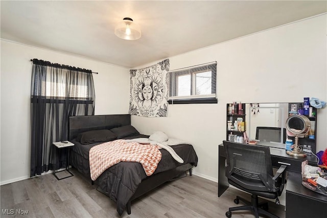 bedroom with baseboards and wood finished floors