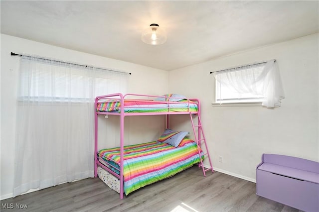 bedroom featuring baseboards and wood finished floors