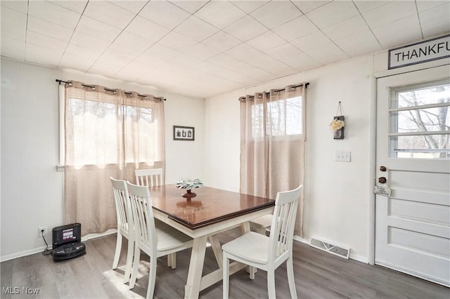 dining area with visible vents, baseboards, and wood finished floors