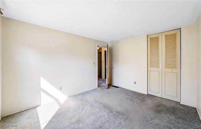 unfurnished bedroom with a closet and carpet floors