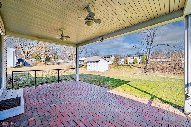 view of patio / terrace featuring a residential view, an outdoor structure, a ceiling fan, and a shed