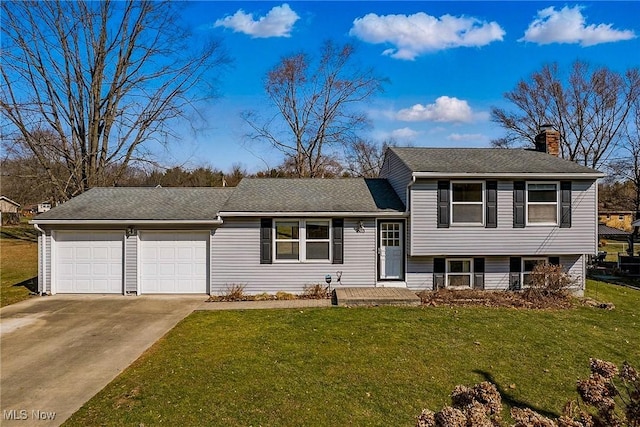 tri-level home featuring a shingled roof, a front lawn, a chimney, a garage, and driveway