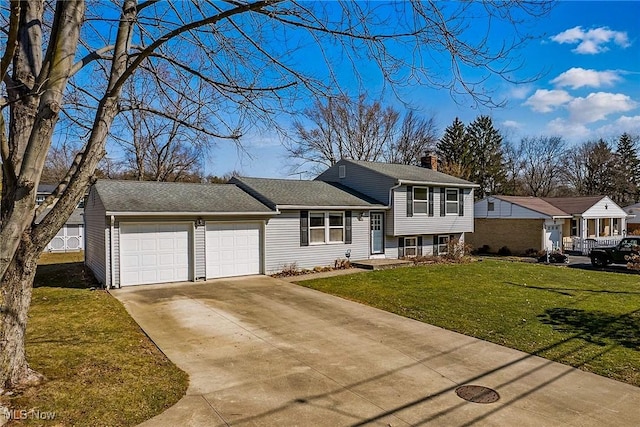 split level home featuring a front lawn, a garage, and driveway