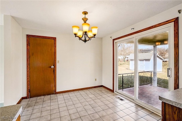 interior space featuring light tile patterned floors, baseboards, and a chandelier