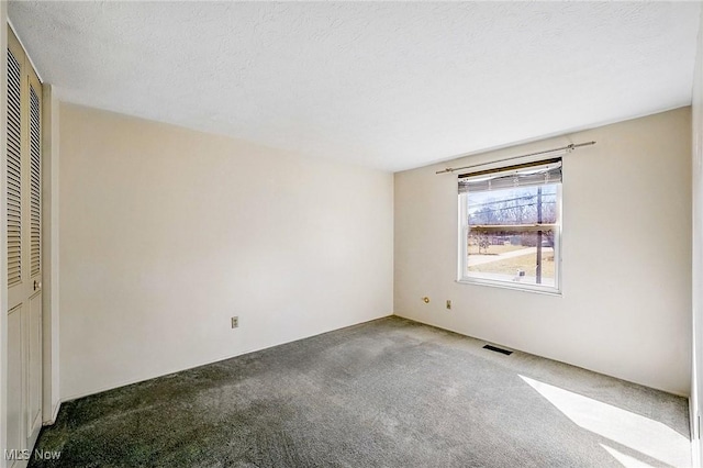 unfurnished bedroom featuring carpet flooring, visible vents, a closet, and a textured ceiling