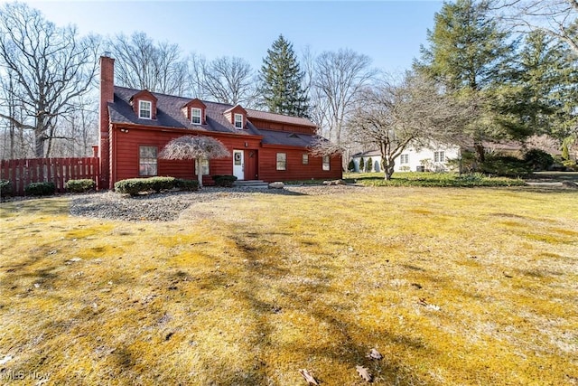 exterior space featuring a front lawn, fence, and a chimney