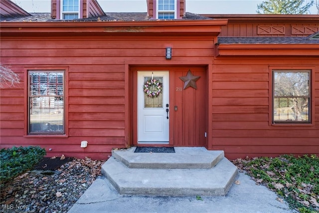 doorway to property featuring a shingled roof