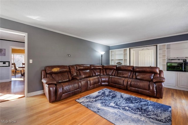 living area with crown molding, wood finished floors, and baseboards