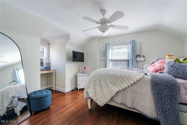 bedroom featuring a ceiling fan, wood finished floors, baseboards, lofted ceiling, and a textured ceiling