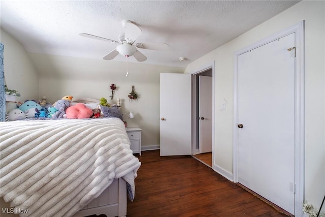 bedroom featuring a ceiling fan, a textured ceiling, wood finished floors, baseboards, and vaulted ceiling