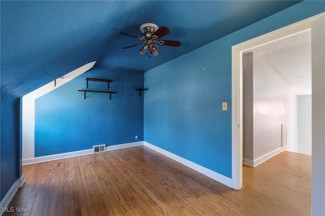 additional living space with visible vents, wood-type flooring, baseboards, and a ceiling fan