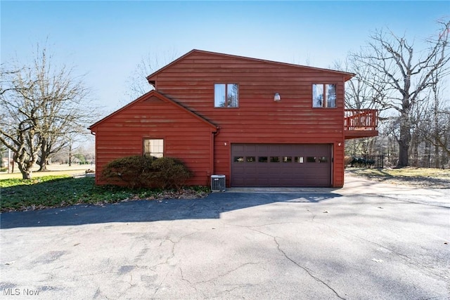 view of property exterior with aphalt driveway and a garage