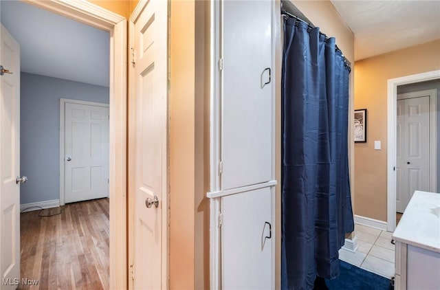 bathroom with vanity, a shower with curtain, wood finished floors, and baseboards