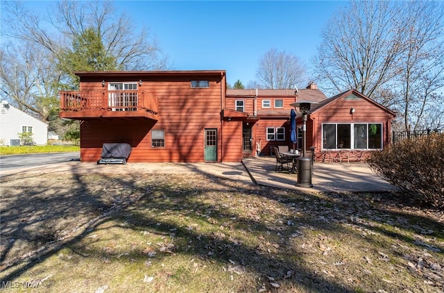 back of house with a balcony and a patio