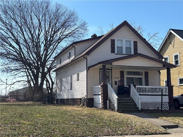 bungalow with covered porch, a chimney, and a front yard