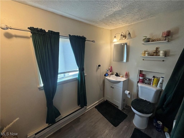 bathroom featuring vanity, toilet, wood finished floors, and a textured ceiling