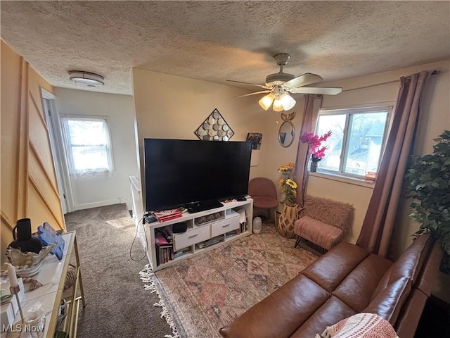 living room featuring ceiling fan, a textured ceiling, and carpet