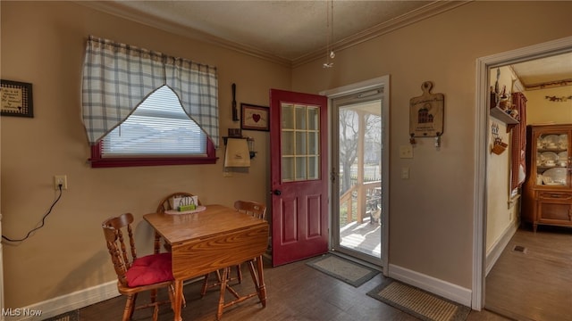 dining area featuring crown molding, baseboards, and a wealth of natural light