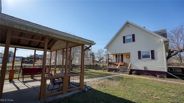 rear view of house featuring a yard and fence