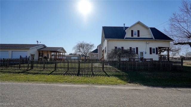 view of home's exterior featuring a lawn, a gambrel roof, and a fenced front yard